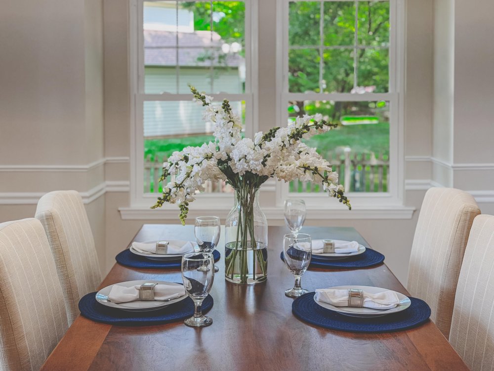 Set dining table with blossoms by the window