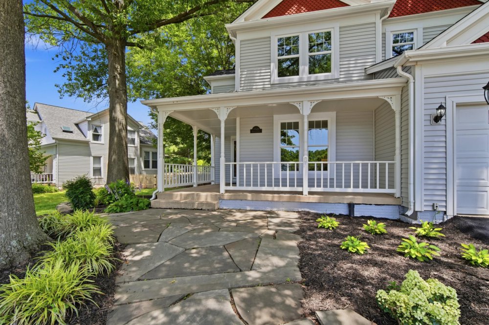Victorian with wraparound porch under mature trees